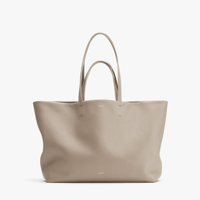 Leather tote bag standing upright against a plain background.