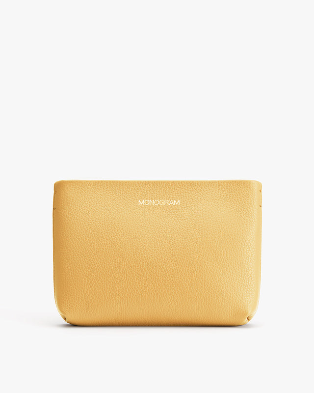 Yellow pouch with text 'MONOGRAM' embossed on lower right corner.