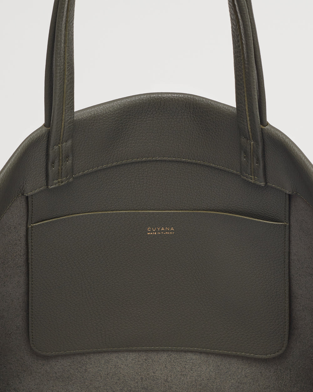 Close-up view of a handbag with dual handles and a front pocket.