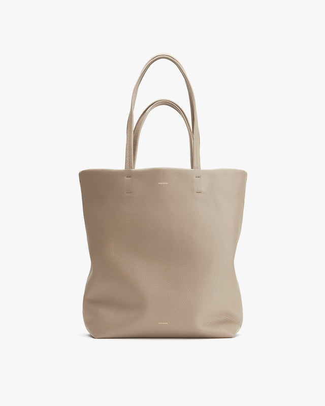 Tote bag with two handles standing upright on a plain background.