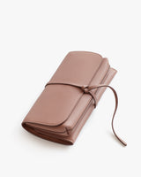 Closed wallet with a wraparound tie on a plain background.
