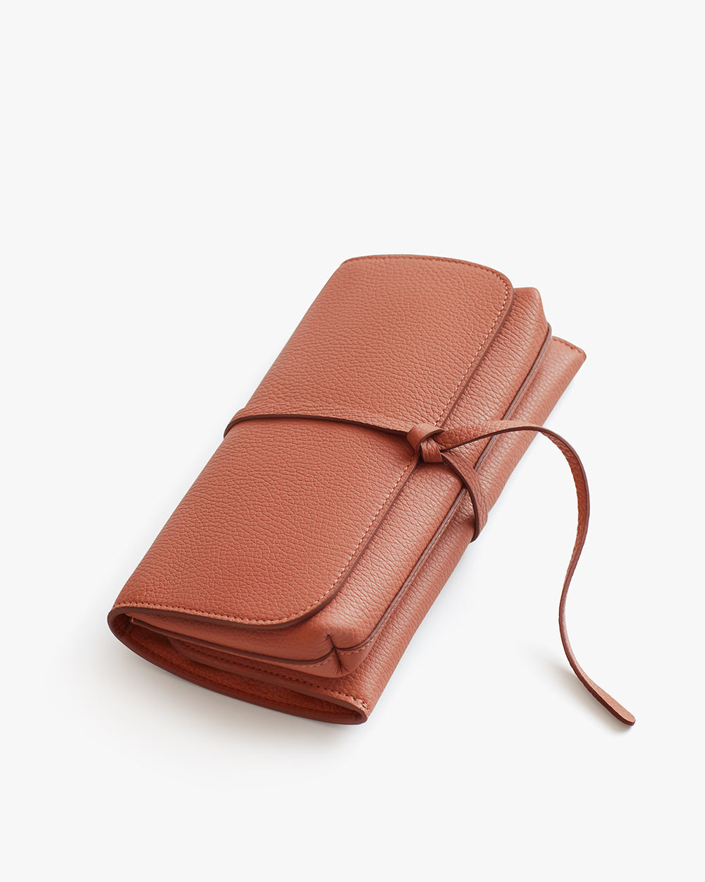 Leather wallet with wrap-around tie closure on a white background.