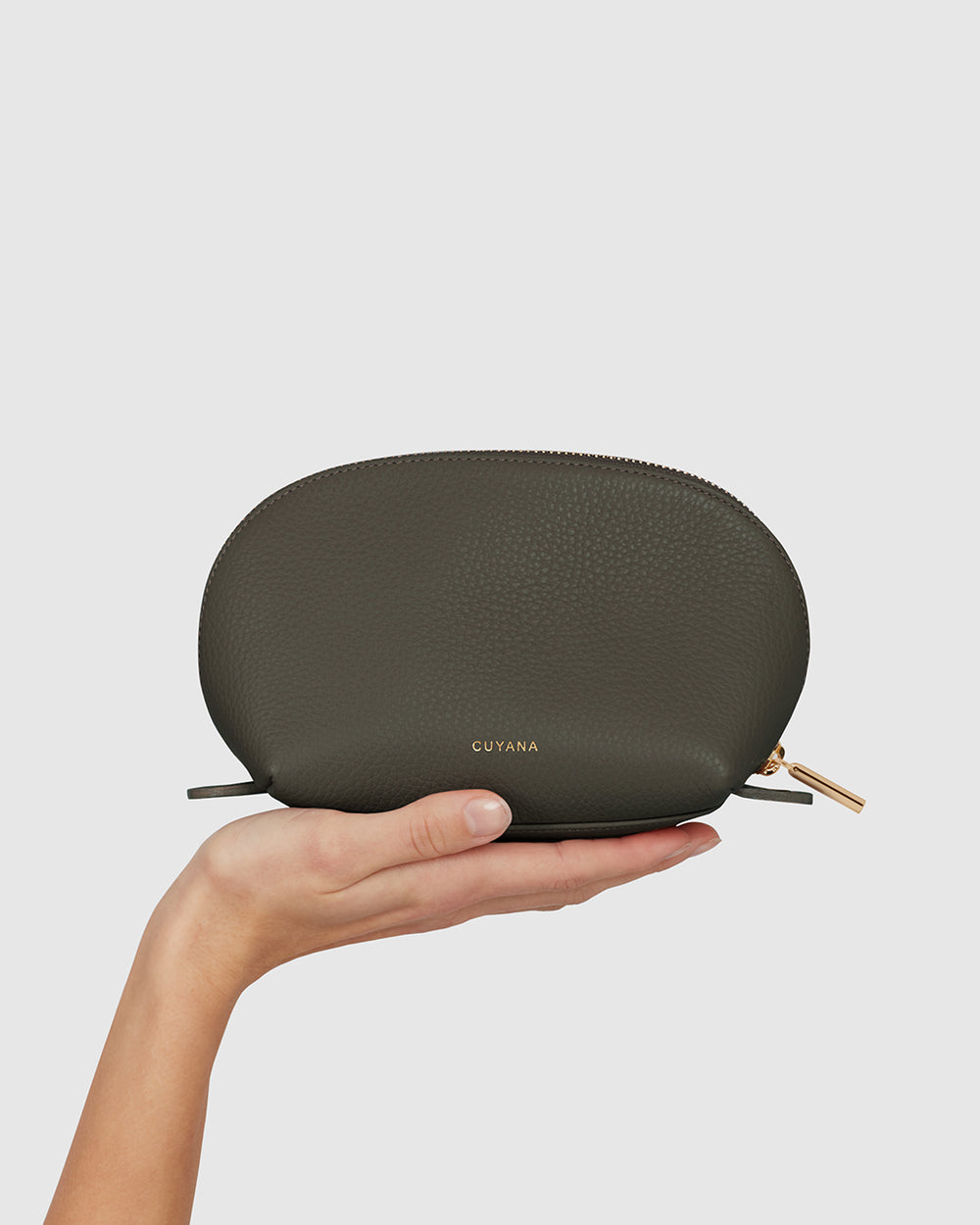 Hand holding a small, textured zipper pouch.
