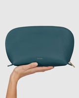 Hand holding a zipped pouch with brand name embossed
