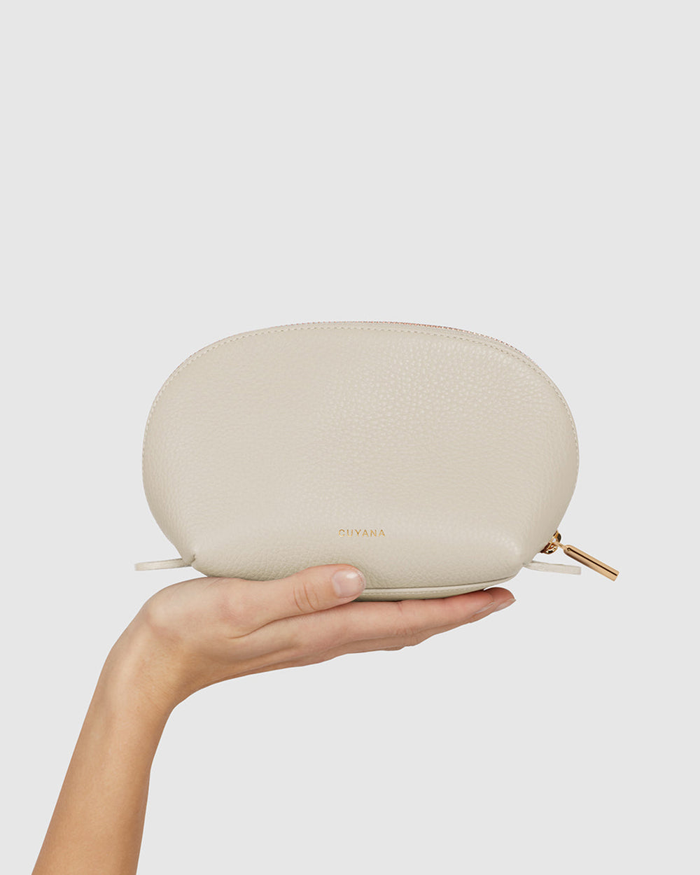Hand holding a small zippered pouch