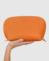 Hand holding a textured zippered pouch.