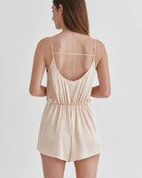 Woman seen from the back wearing a sleeveless short jumpsuit.