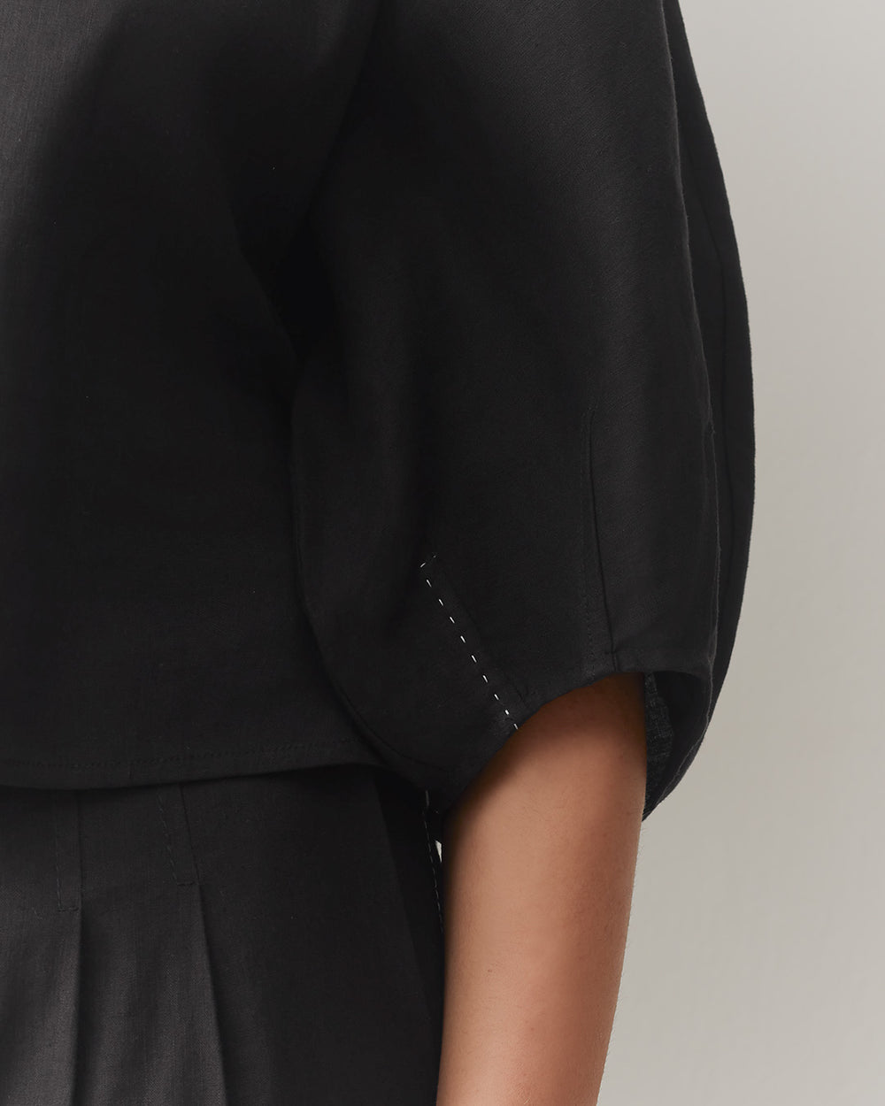 Close-up of a person's arm in a short-sleeved top.