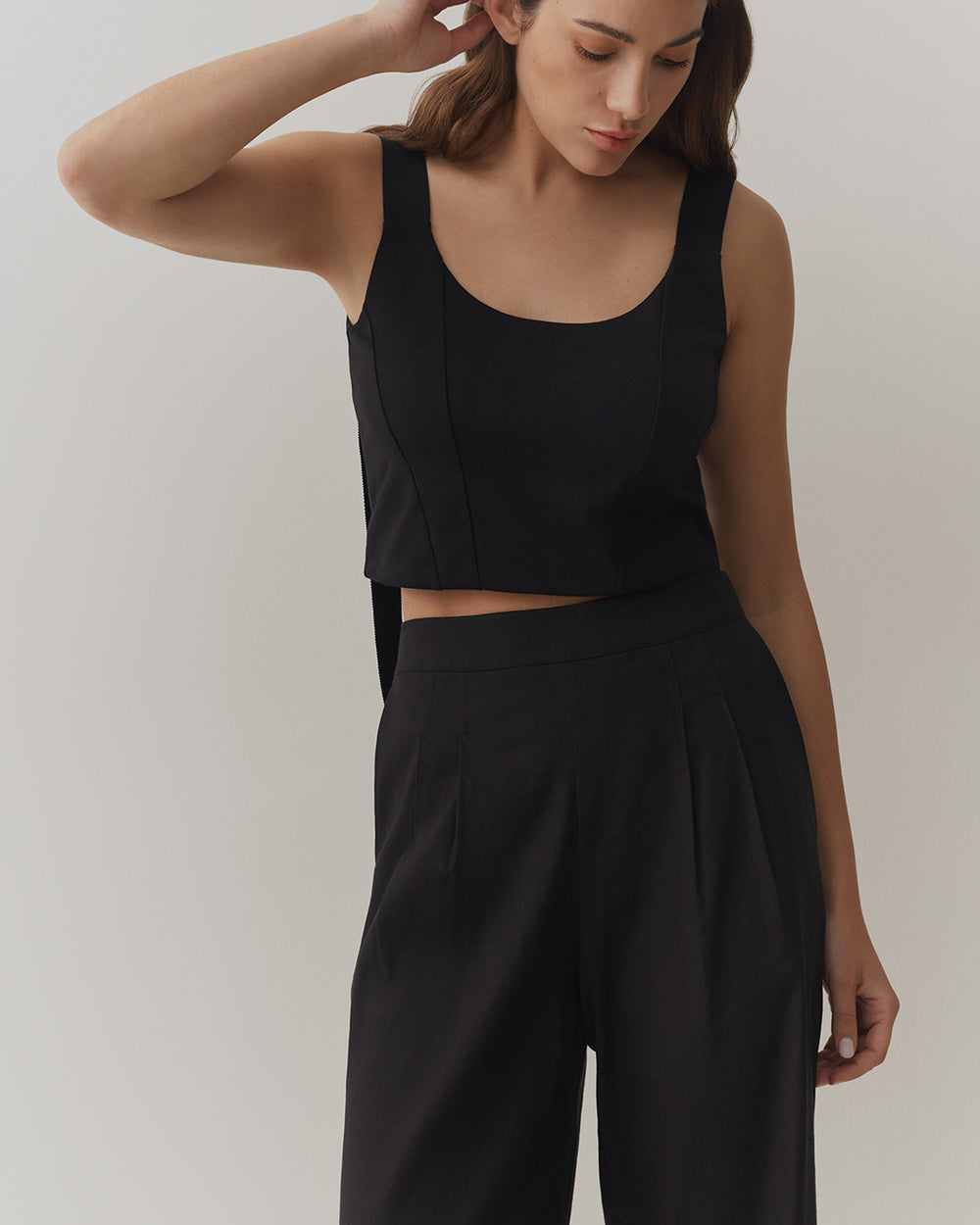 Linen Pleated Wide-Leg Pant Woman in tank top and trousers posing with hand on head.