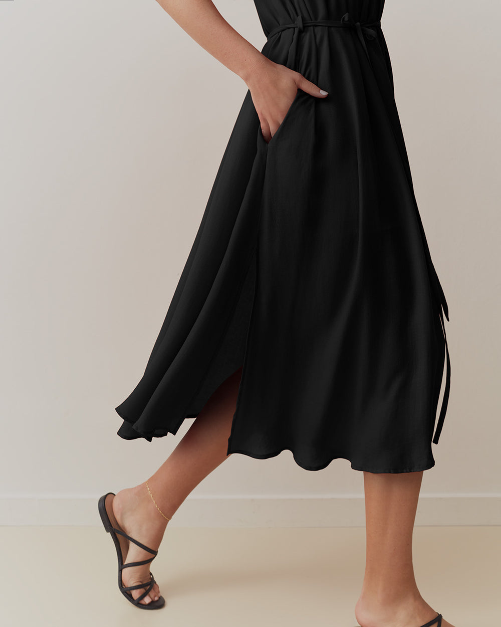 Person wearing a mid-length skirt and heels, walking.