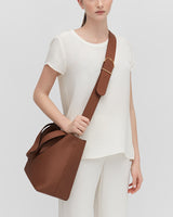 Person wearing a large handbag with a wide shoulder strap.