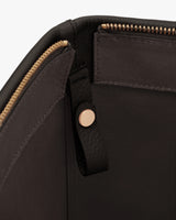 Interior of a bag with a zipper and a buttoned strap.