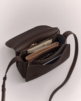 Open handbag with a strap, displaying compartments and wallets inside.
