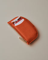 Small curved pouch with zip closure and slide pockets on the front