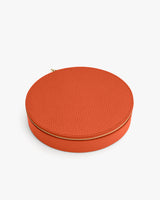Oval leather zippered case on a flat surface.