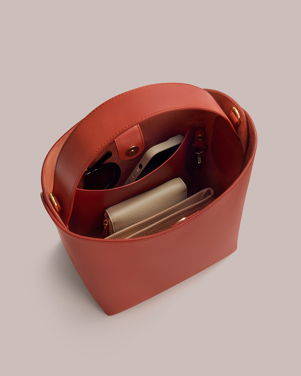 Linea Bucket Bag Open handbag with wallet, sunglasses, and keys inside.