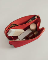 Open toiletry bag with makeup and brushes inside.