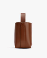 Small leather handbag with a single handle standing upright.