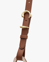 A leather strap with gold metal buckle detail.