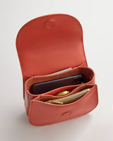 Open purse with two compartments, holding a phone and a small zippered pouch.
