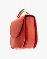A handbag with a curved top handle and flap closure.