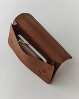 Open leather clutch with a wallet and a phone inside.