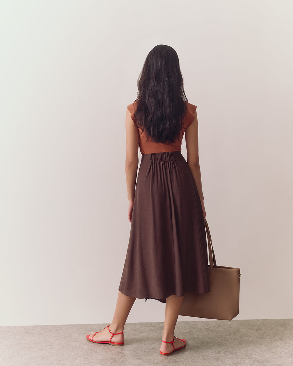 Linen Wrap Skirt Person wearing a T-shirt and skirt, facing away, standing on a plain floor.