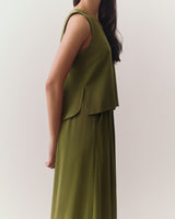 Person wearing a sleeveless top and pants in profile.