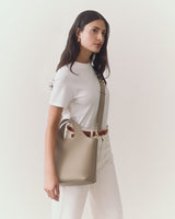 Person holding a handbag, wearing a short-sleeve top and pants.