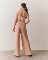 Woman walking in sleeveless top and wide-leg pants.