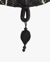 Woven tassel detail with loop and two beads hanging from it.
