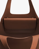 Open handbag with textured surface and pocket inside.