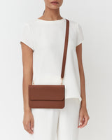 Person wearing a short-sleeve outfit with a crossbody bag