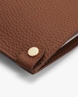 Close-up of textured leather laptop sleeve with button detail