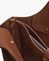 Open leather bag with laptop sleeve and metal snap buttons.