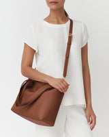 Person wearing a short-sleeve outfit with a crossbody bag