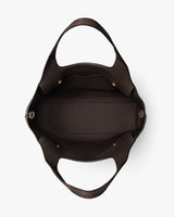Open empty handbag with wide straps and buckle details seen from above.