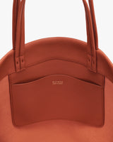 Tote bag close-up with brand logo on interior pocket.