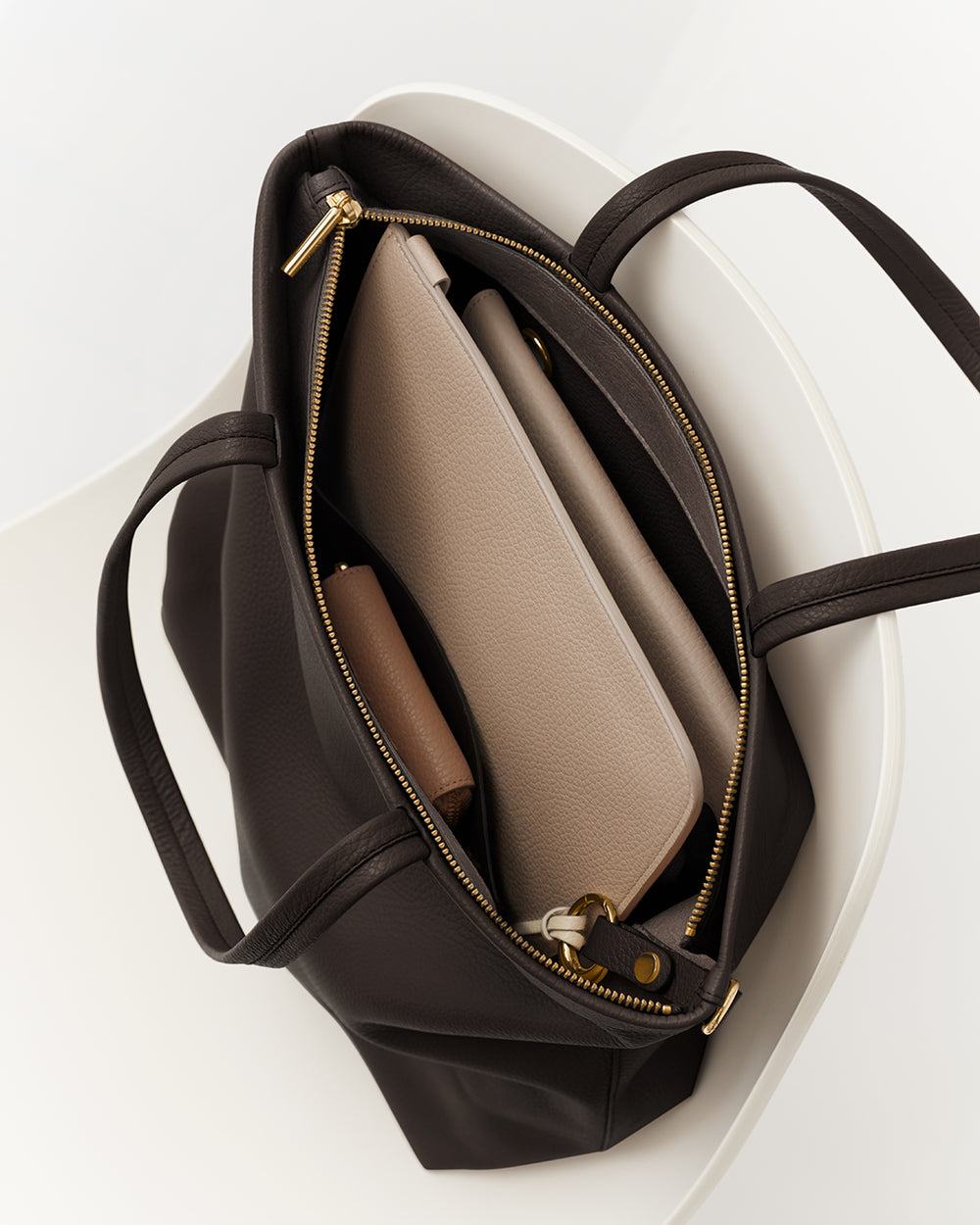 Open tote bag on chair with pouches inside