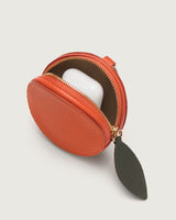 Round coin pouch with open zipper and a small item inside.