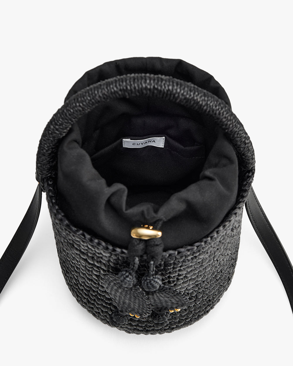 Woven bag with drawstring closure and shoulder strap shown from top view.