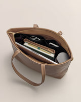 Tote bag filled with items like books, a pen, and bottles.