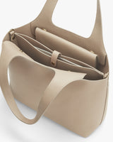Open handbag with internal compartments and handles.