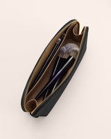 Makeup bag with brushes inside, top view.