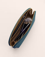 Makeup bag with brushes inside and zipper partially open.