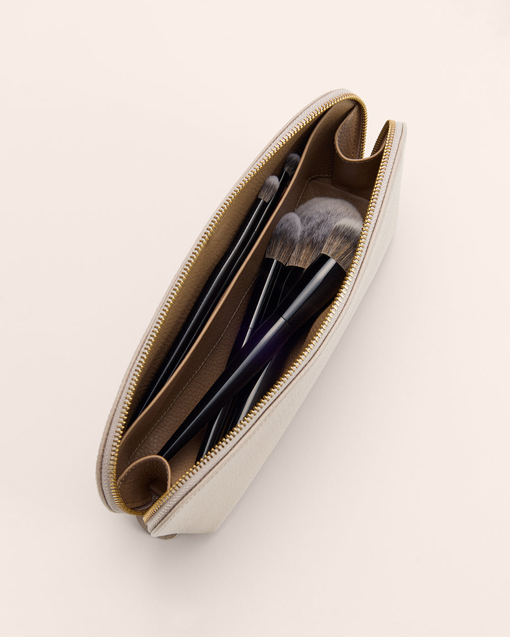 Open makeup pouch with brushes inside.