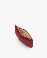 Small zippered pouch with curved design, open to show interior.