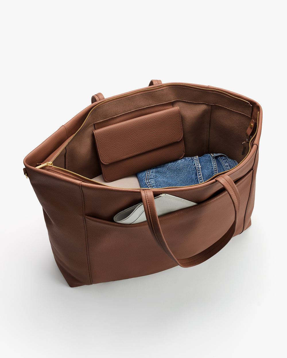 Open travel bag with a wallet, denim fabric, and white item inside