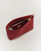 Small open pouch with items and a zipper on a flat surface.