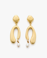 Abstract gold earrings with dangling pearl accents.